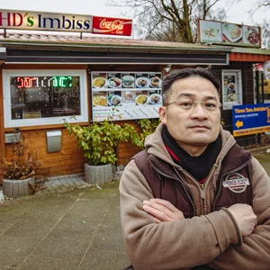 Imbissbesitzer steht vor seinem Laden