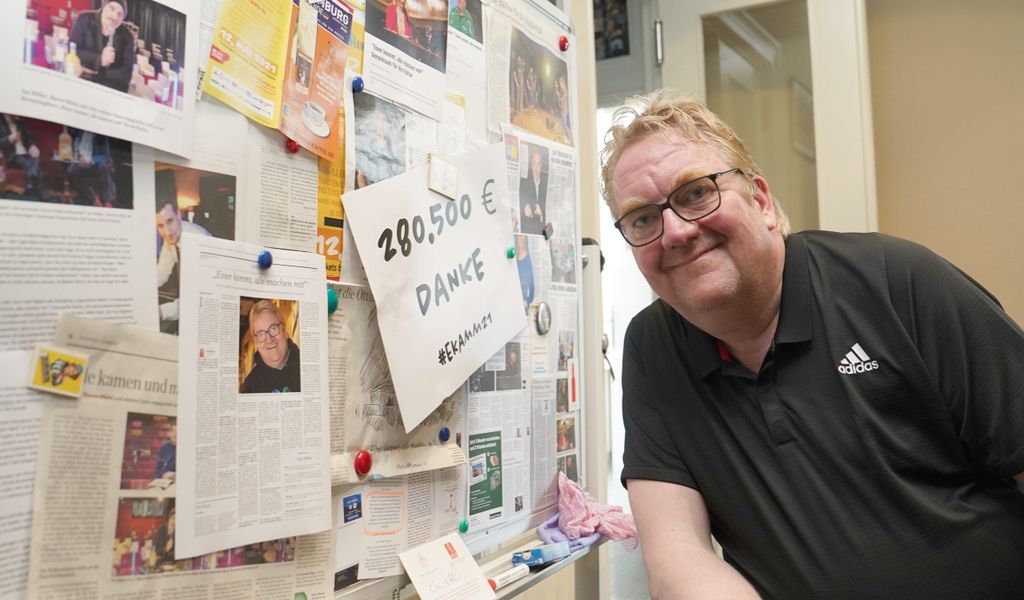 Lars Meier lehnt sich an eine Wand mit Zeitungsausschnitten