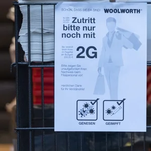 Ein Schild "Zutritt bitte nur noch mit 2G" hängt im Eingang eines Kaufhauses