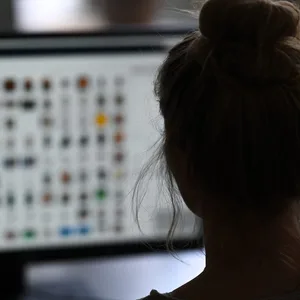 Eine Kriminaloberkommissarin sitzt in einem Büro vor einem Auswertungscomputer auf der Suche nach Kinderpornografie und Fällen von sexuellem Missbrauch.