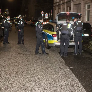 Hamburger Polizisten stehen vor dem Wohnhaus und bewaffnen sich.