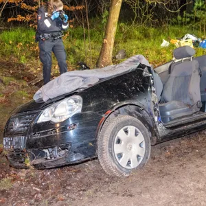 Eine Polizistin macht Fotos von dem Unfallwrack.