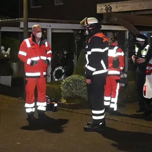 Einsatzkräfte stehen vor einem Haus