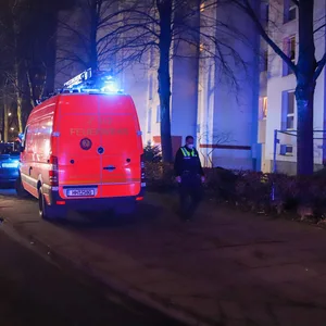 Feuerwehrautos stehen vor einem Mehrfamilienhaus