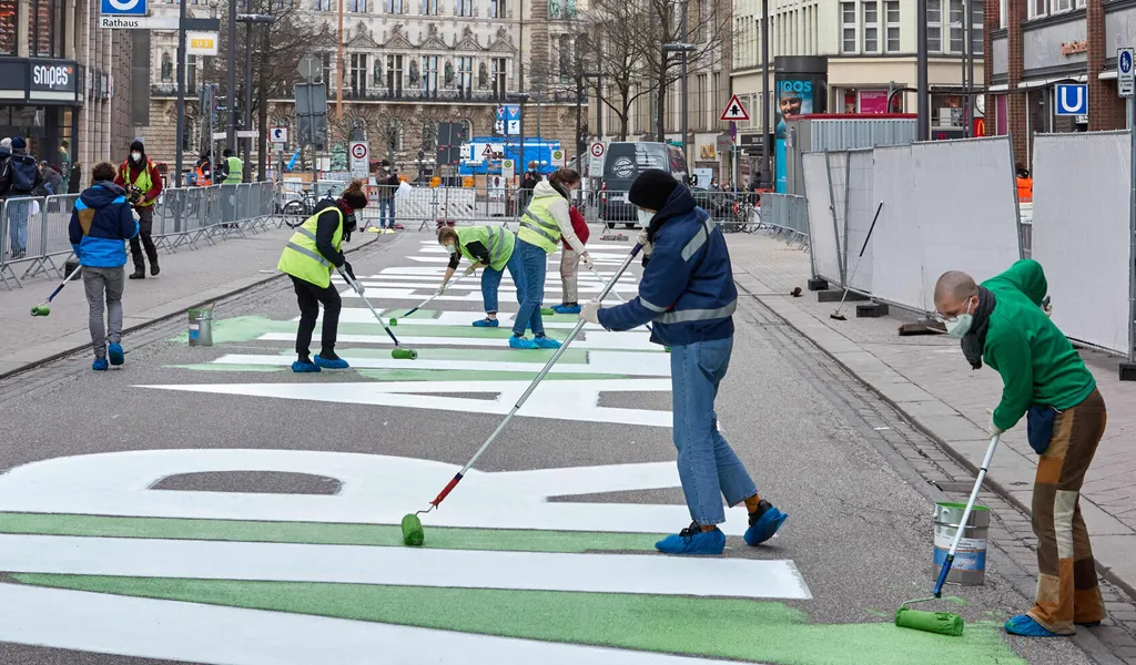 Aktivisten von Fridays for Future malen den Schriftzug „WIR ALLE FÜR 1,5 GRAD“ auf die Mönckebergstraße.