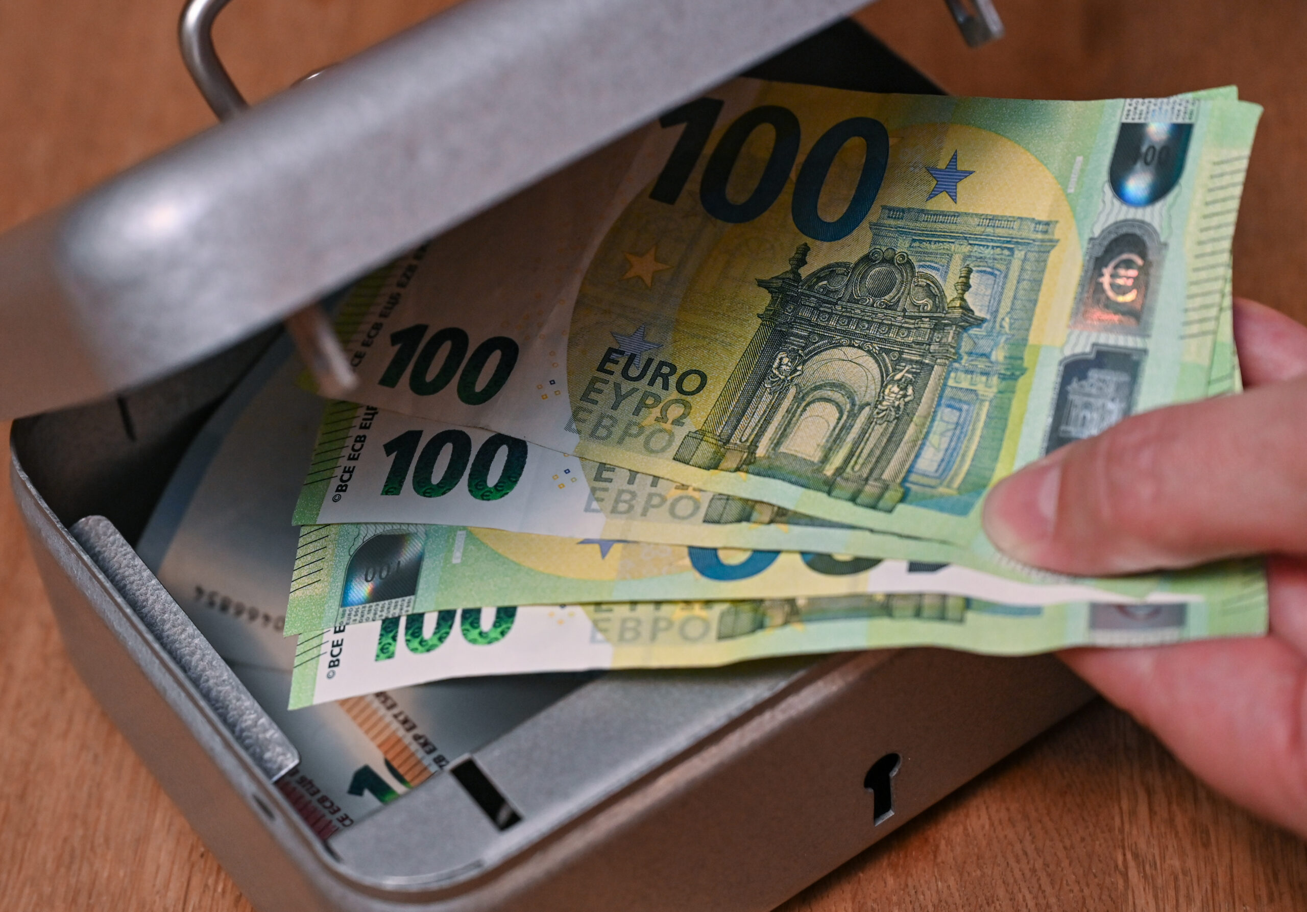 Eine Frau holt Eurobanknoten aus einer kleinen Geldkassette. (Symbolbild)
