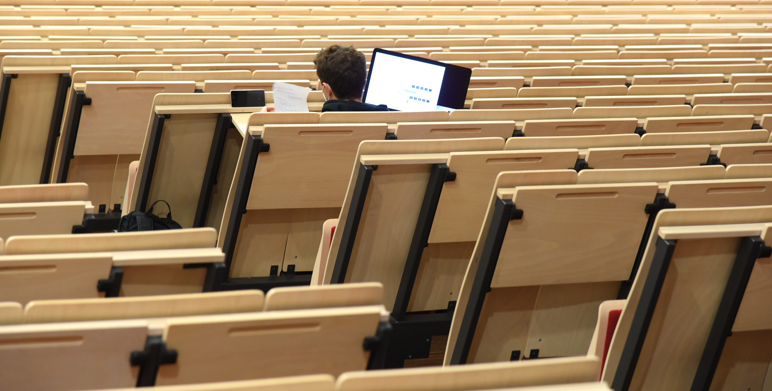 Ein Student sitzt allein im Vorlesungssaal