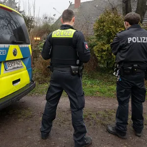 Zwei Polizisten stehen vor einem Haus, in dem am 28. Dezember zwei Tote gefunden wurden.
