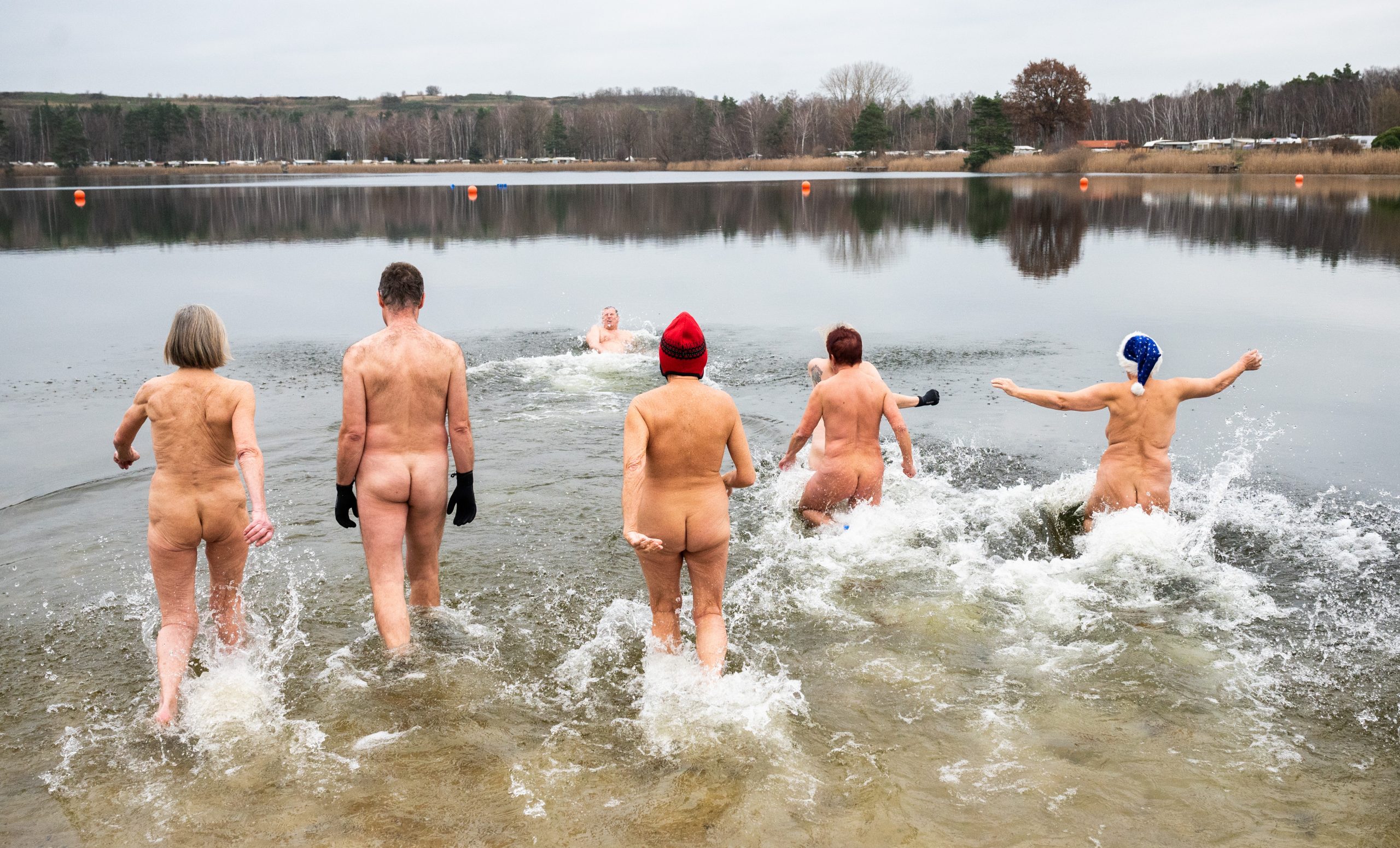 Nackte Schwimmer laufen beim 7. Neujahrs-Nackt-Schwimmen in den Sonnensee.