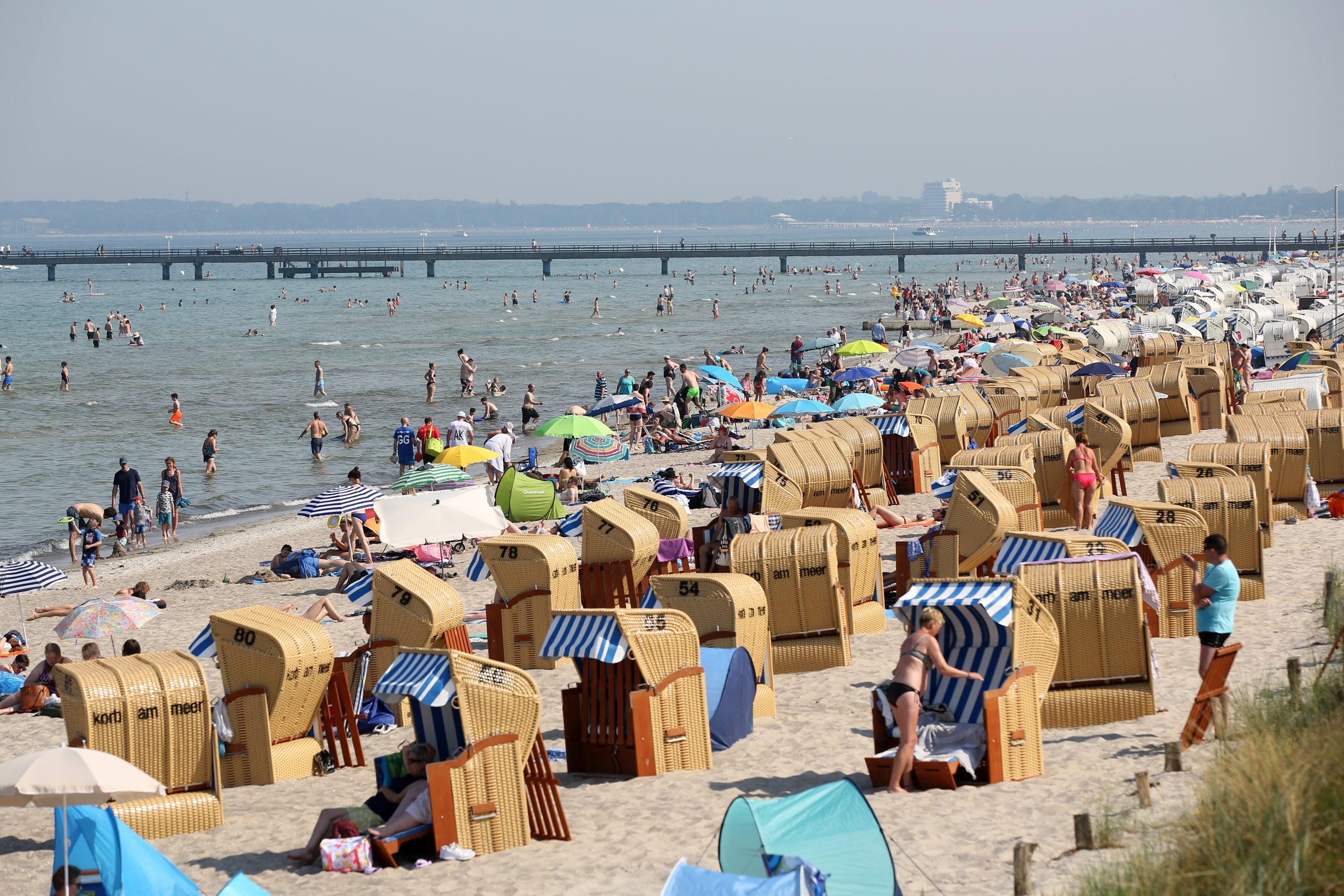 Der Strand von Scharbeutz ist bei Sonnenschein und Temperaturen um die 30 Grad Celsius mit Badegästen und Strandkörben gut gefüllt.