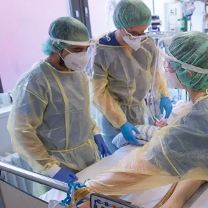 Pfleger und Pflegerinnen sowie eine Ärztin kümmern sich auf einer Intensivstation um einen Corona-Patienten. (Symbolbild)