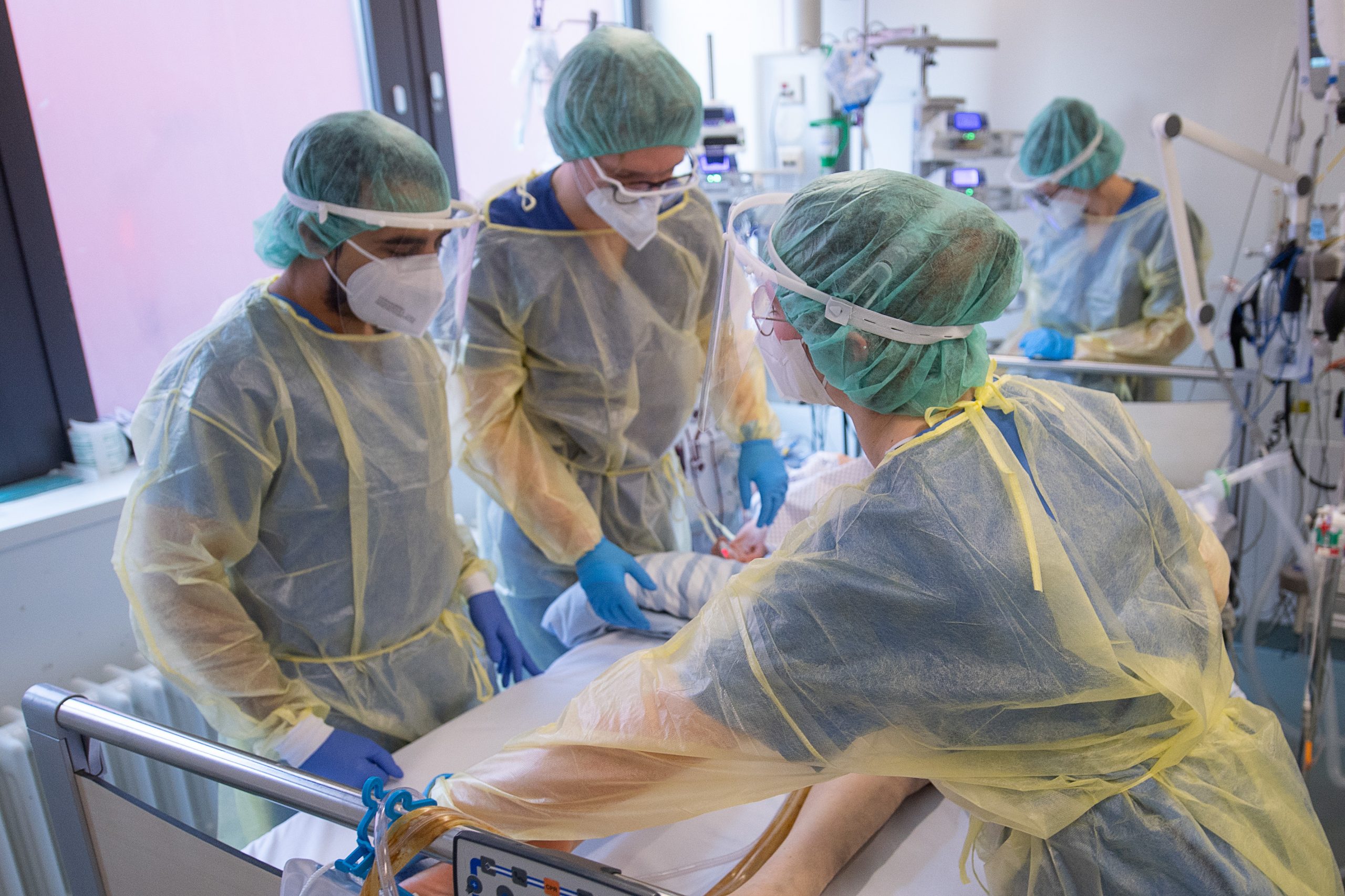 Pfleger und Pflegerinnen sowie eine Ärztin kümmern sich auf der Intensivstation für Corona-Patienten