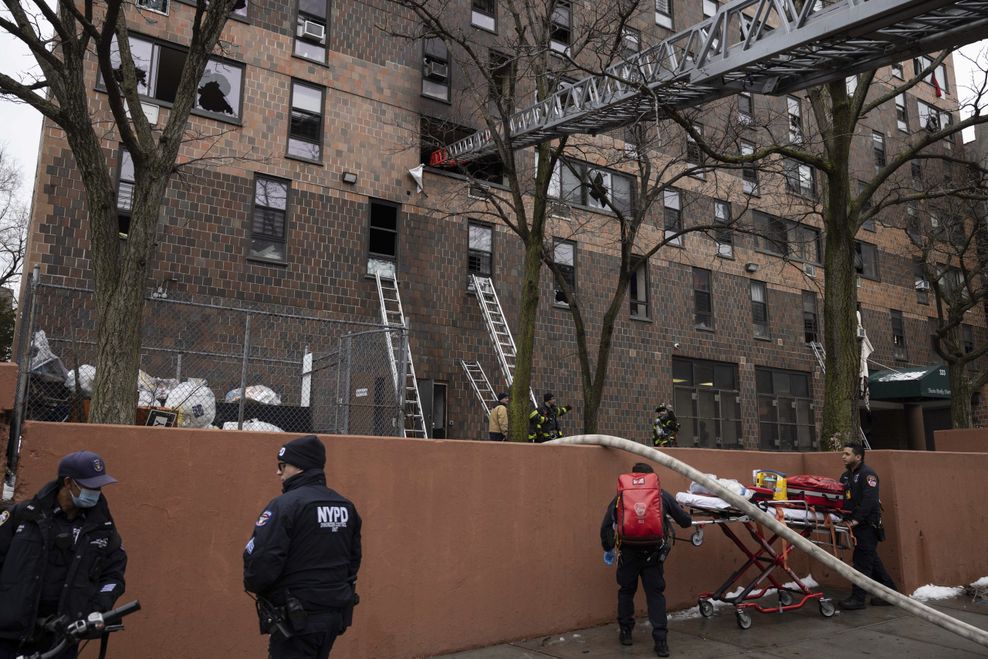Feuerwehrleute und NYPD-Beamte arbeiten nach einem Brand im Stadtviertel Bronx vor einem Wohnhaus. 