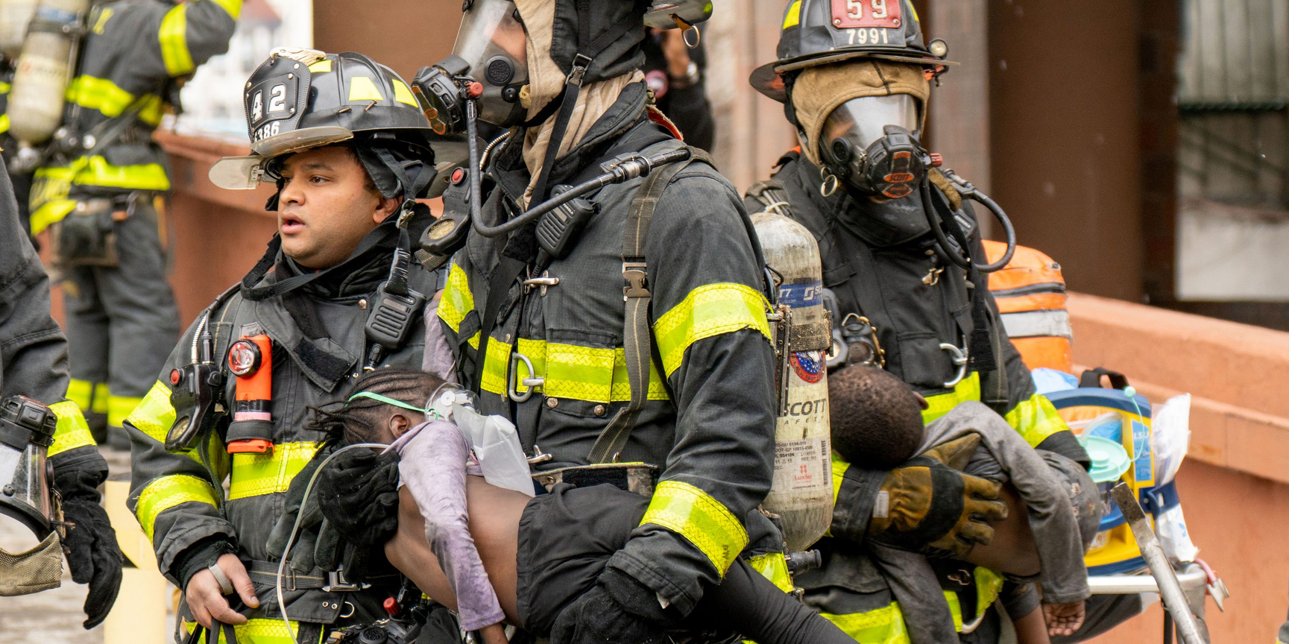 Feuerwehrleute tragen Kinder aus einem Wohnhaus in der Bronx.