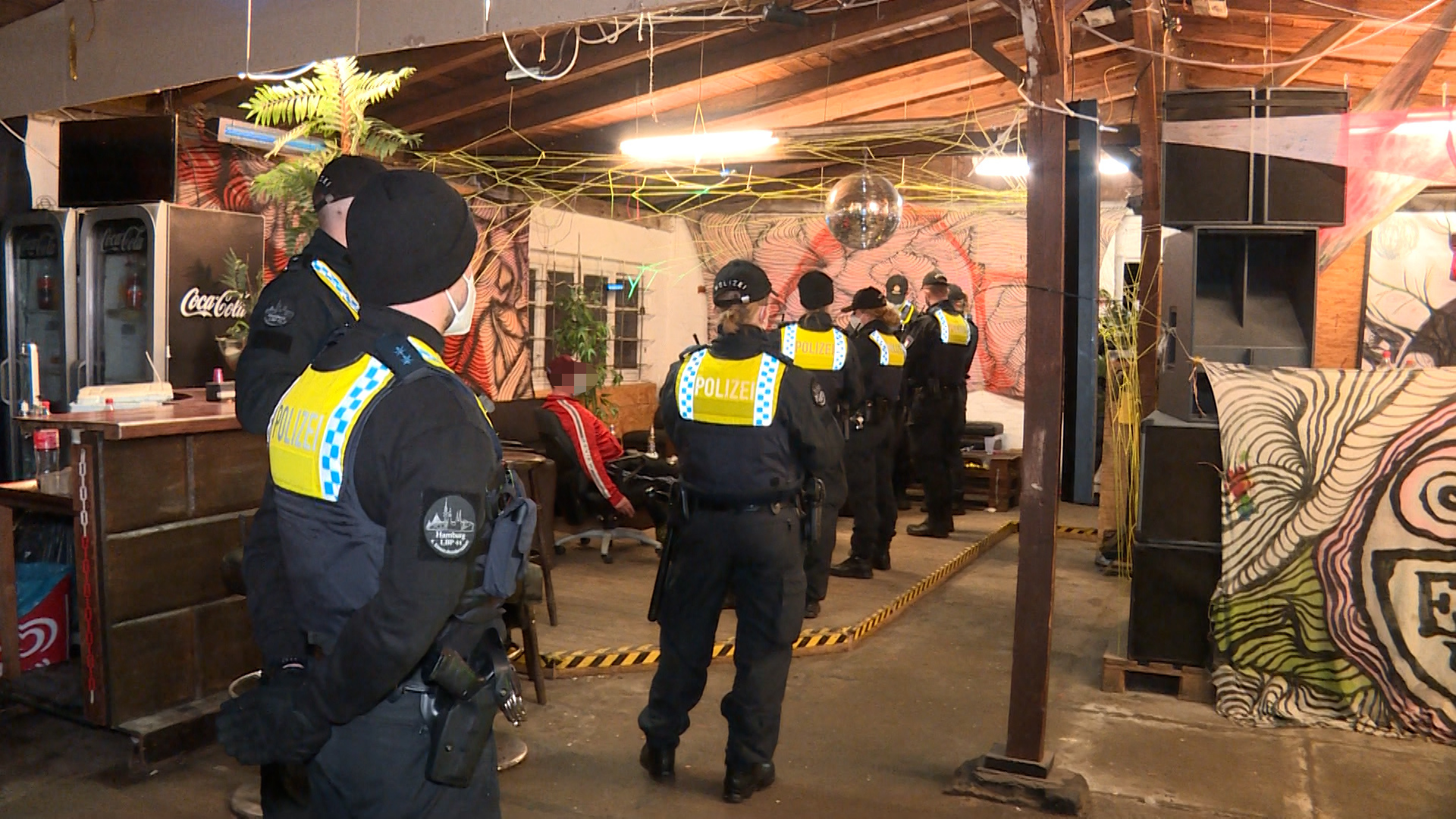 Polizeikräfte kontrollieren Gäste in dem Bootshaus.