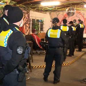 Polizeikräfte kontrollieren Gäste in dem Bootshaus.