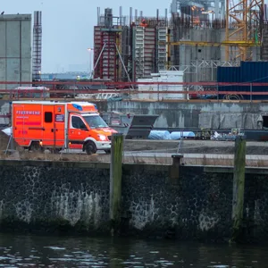 Ein Rettungswagen steht vor der Baustelle. Ein Arbeiter kam bei einem Sturz ums Leben.