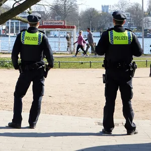 Polizisten stehen an der Außenalster in der Nähe vom Bootsanleger Fährdamm und machen Corona-Kontrollen.