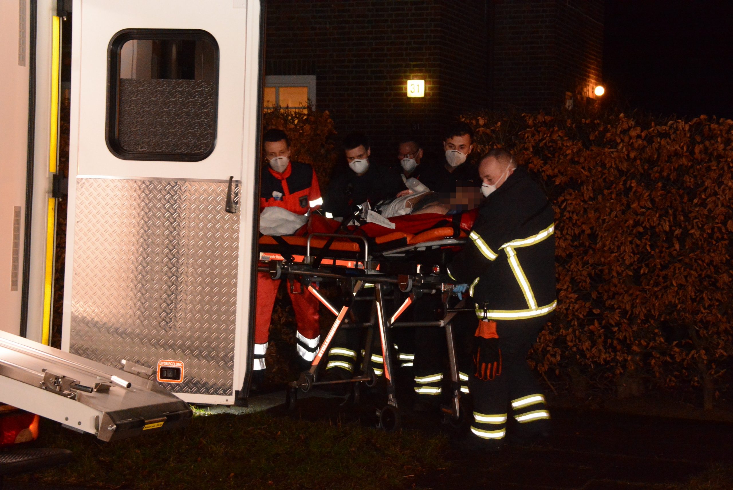 Rettungskräfte bringen einen Mann auf einer Trage zum Krankenwagen
