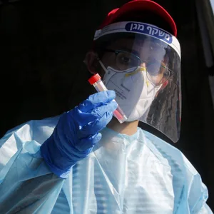 Ein medizinischer Mitarbeiter in Petich Tikwa hält eine Corona-Probe in der Hand (Symbolbild).