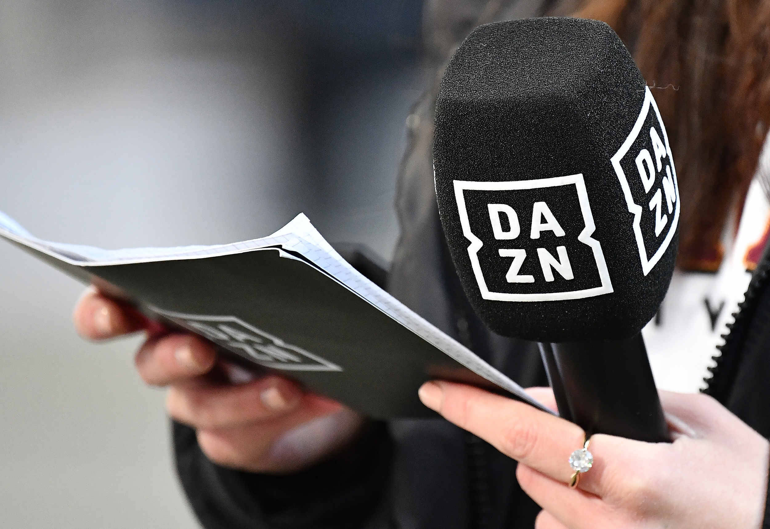 Eine Moderationskarte und ein Mikrofon von DAZN.