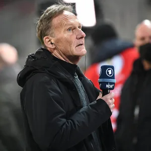 Hans-Joachim Watzke mit ARD-Mikrofon in der Hand.