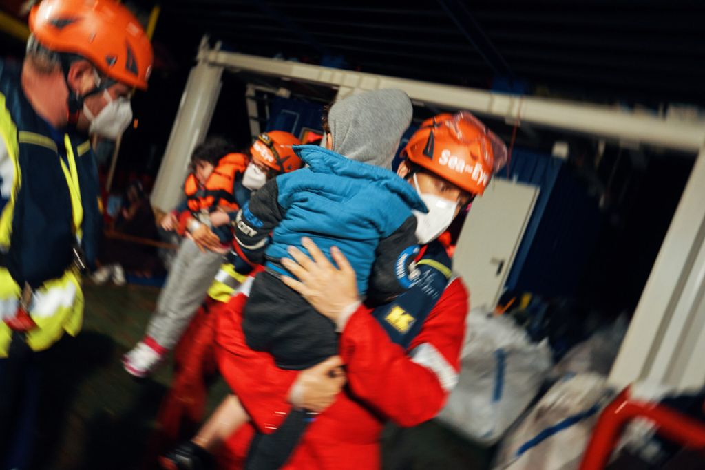 Tobi Schlegl trägt ein gerettetes Kind auf der „Sea-Eye 4“