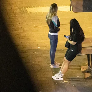 Zwei junge Prostituierte warten im Schein einer Laterne