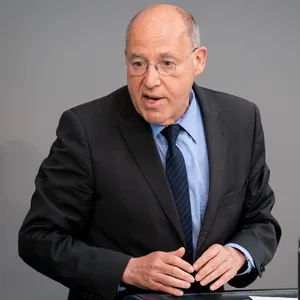 Gregor Gysi: Mann mit Brille und Anzug an einem Rednerpult