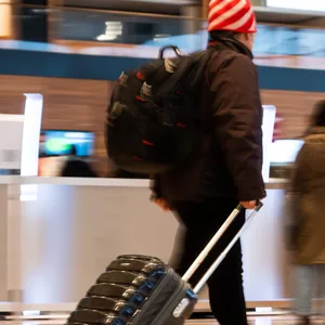 Menschen gehen im Terminal 1 am Flughafen Berlin Brandenburg durch die Haupthalle.
