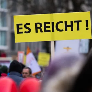 EIn Schild mit der Aufschrift "ES REICHT!" ist während einer "Querdenker"-Demonstration zu sehen