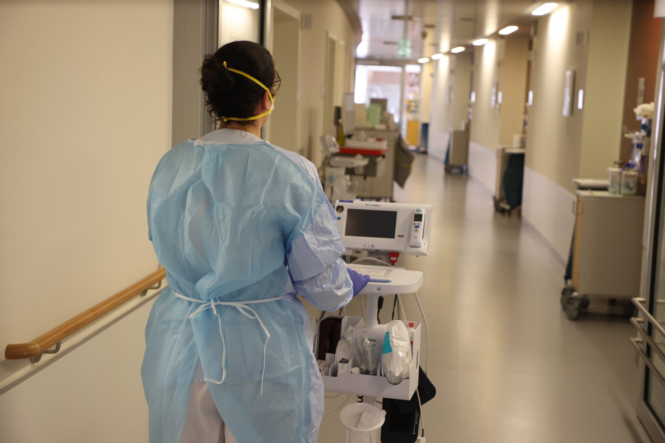 Eine Krankenschwester läuft mit medizinischem Gerät auf der Corona «Normalstation»