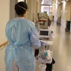 Eine Krankenschwester läuft mit medizinischem Gerät auf der Corona «Normalstation»