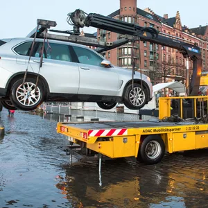 Ein Auto wird am Morgen auf dem überschwemmten Fischmarkt während einer Sturmflut beim Hochwasser der Elbe von einem Abschlepper in Sicherheit gebracht.