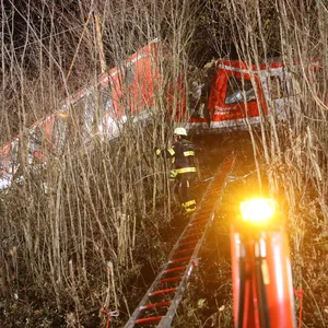 Ein Feuerwehrmann arbeitet an der Unfallstelle. Zwei S-Bahnen sind ineinander gekracht