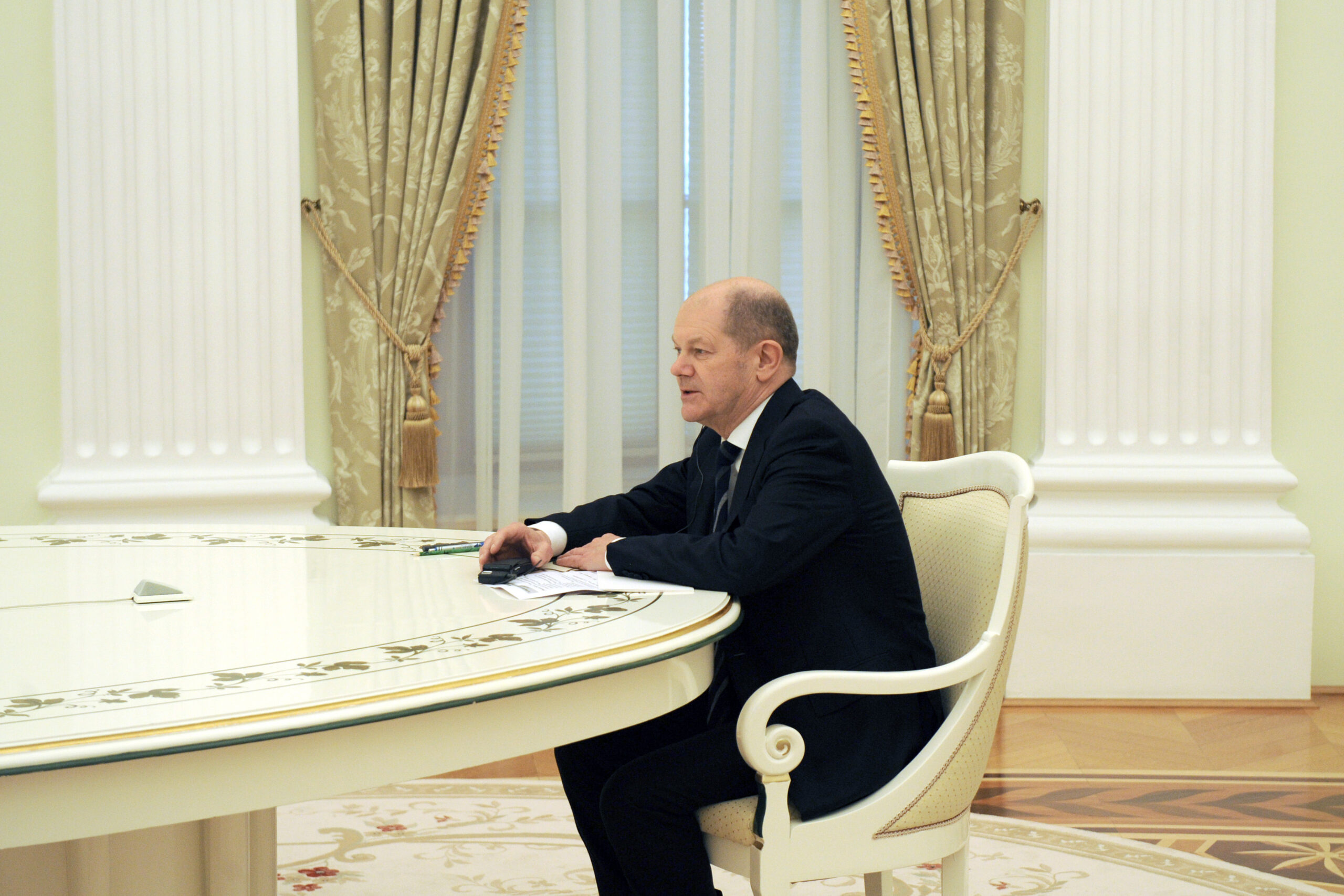 Bundeskanzler Olaf Scholz (SPD) sitzt beim Treffen mit Russlands Präsident W. Putin im Kreml an einem Tisch