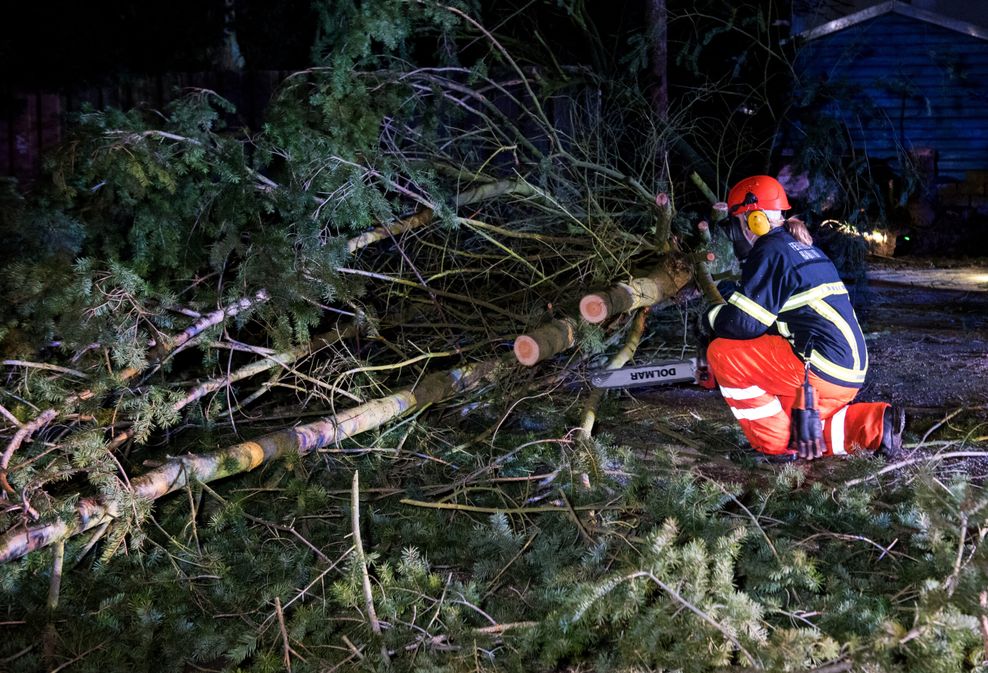 Eine Feuerwehrfrau zersägt im Stadtteil Lohbrügge einen umgestürzten Baum.