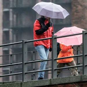 Zwei Menschen mit Regenschirmen in der Speicherstadt.