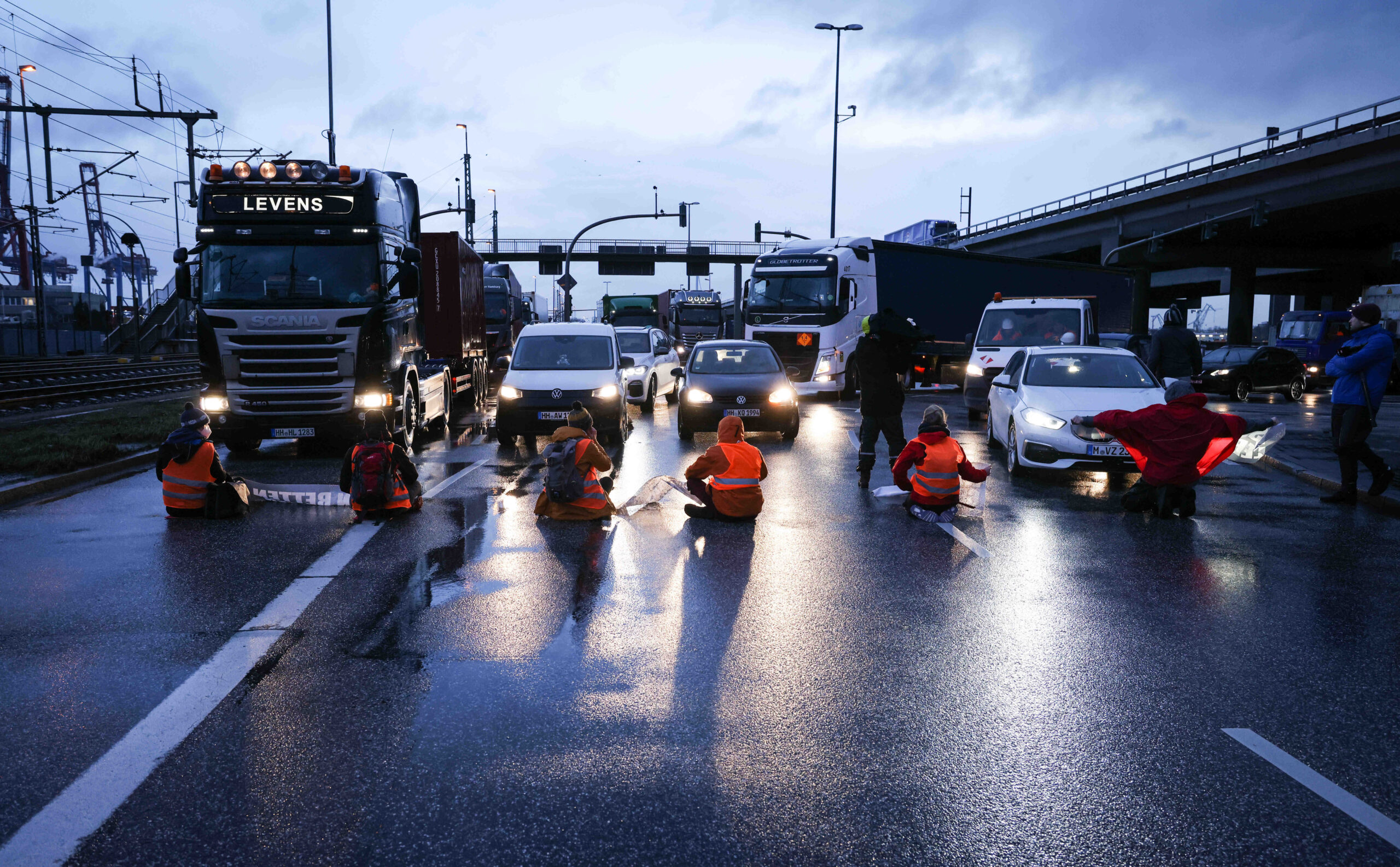 Klimaaktivisten der Aktion „Aufstand der letzten Generation“ blockieren am Morgen eine Kreuzung am Zollamt Waltershof zur Köhlbrandbrücke und zur Autobahn A7.