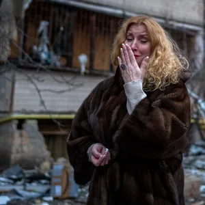 Eine Ukrainerin neben einem Haus, das von einer Rakete zerstört wurde. Am Freitag sind russische Truppen bis nach Kiew vorgerückt.