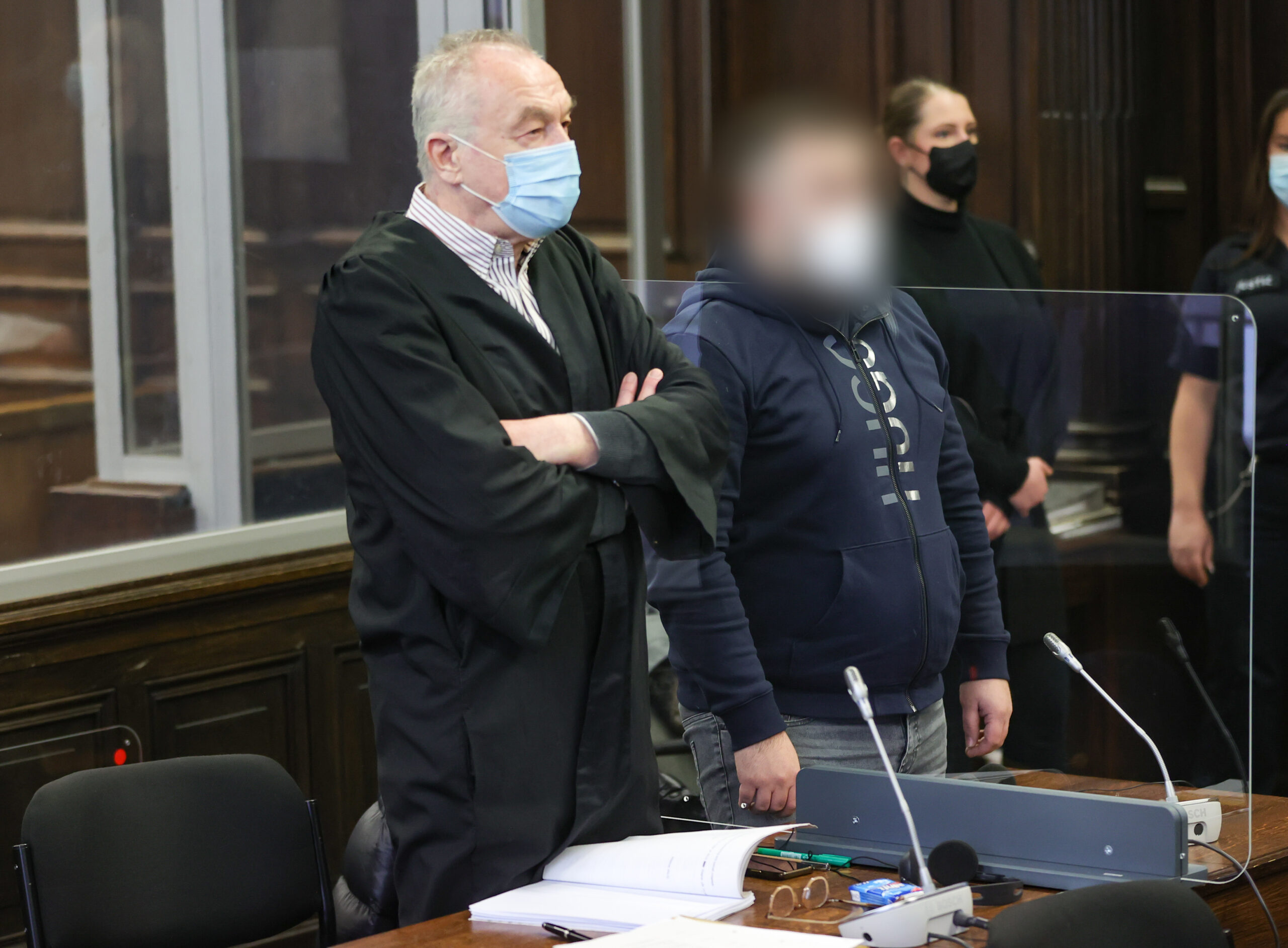Einer der beiden Angeklagten wartet mit seinem Anwalt in einem Gerichtssaal des Strafjustizgebäudes in Hamburg auf den Prozessbeginn.