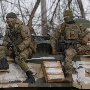 Das von der staatlichen russischen Nachrichtenagentur Sputnik veröffentlichte Bild zeigt russische Soldaten die auf einem gepanzerten Fahrzeug auf einer Straße nahe der Grenze zwischen Russland und der Ukraine mitfahren.