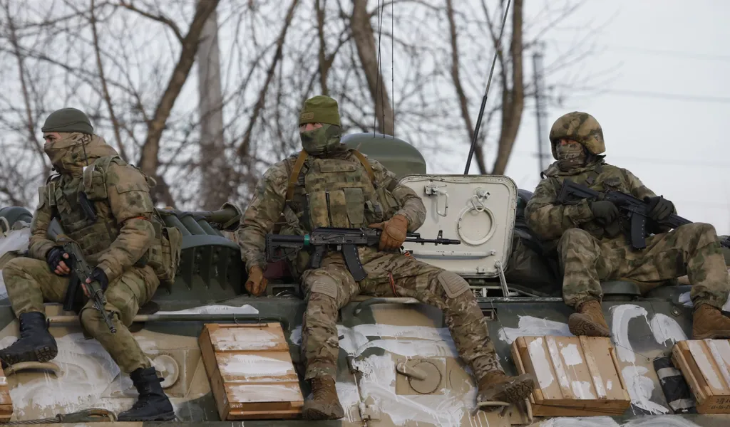 Das von der staatlichen russischen Nachrichtenagentur Sputnik veröffentlichte Bild zeigt russische Soldaten die auf einem gepanzerten Fahrzeug auf einer Straße nahe der Grenze zwischen Russland und der Ukraine mitfahren.
