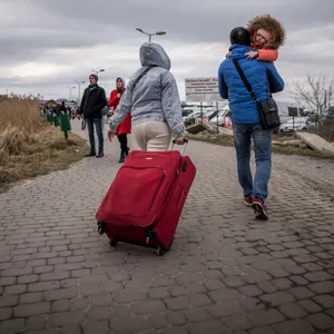 Der Ukrainer Iwan (r) trägt seine Enkelin Diana (4, l) neben seiner Tochter Olena (l) direkt nach ihrem Grenzübertritt von Schehyni in der Ukraine nach Medyka in Polen.