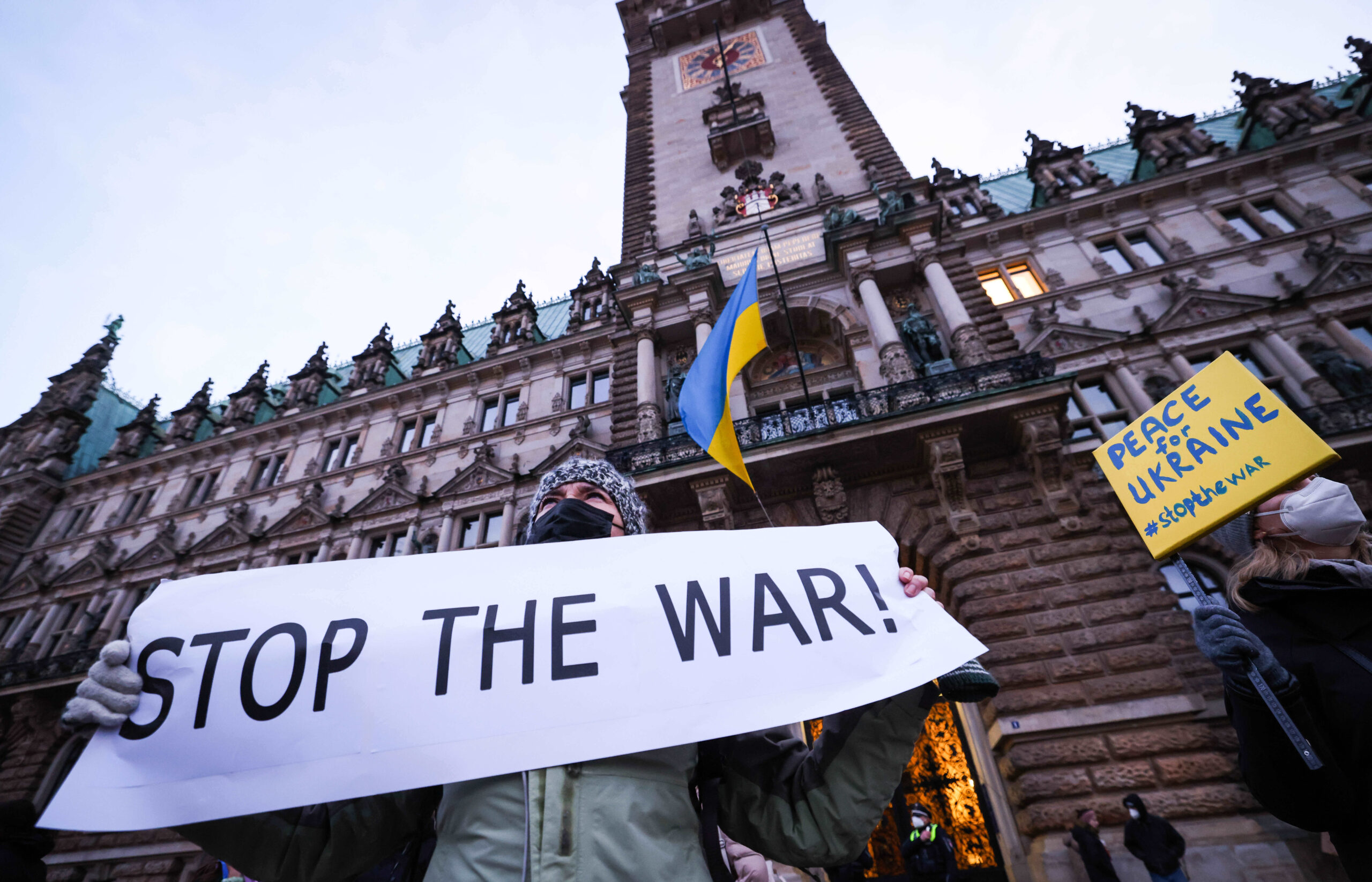 Während Teilnehmer gegen den Krieg in der Ukraine demonstrieren weht am Rathaus eine Ukraine-Flagge.