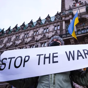 Während Teilnehmer gegen den Krieg in der Ukraine demonstrieren weht am Rathaus eine Ukraine-Flagge.