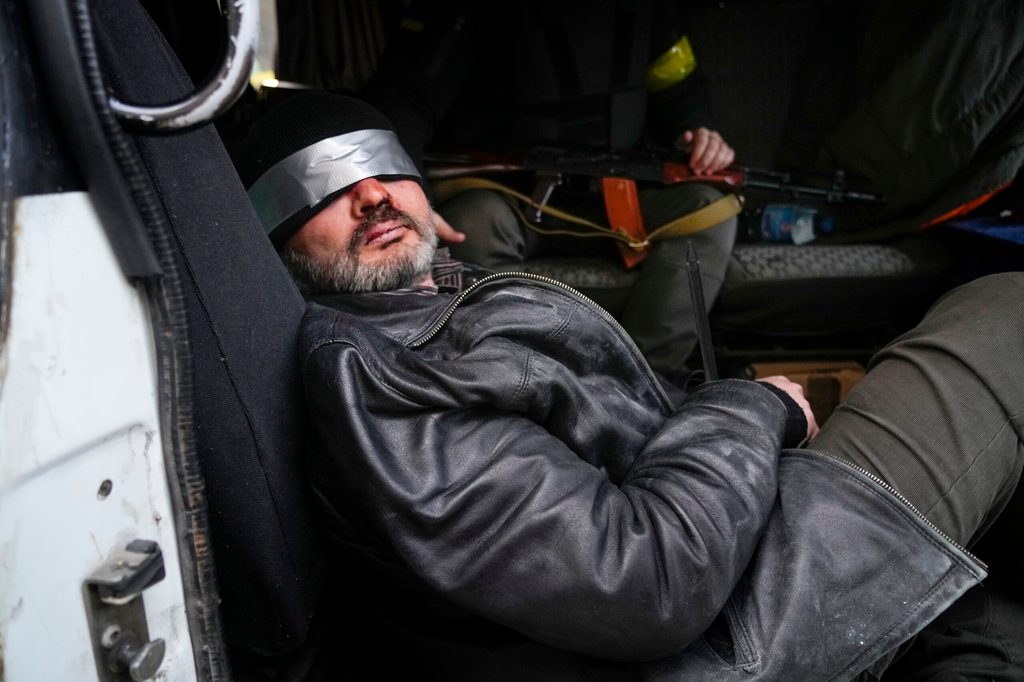 Ukrainische Soldaten halten einen Mann fest, den sie für einen russischen Agenten halten.