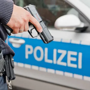 Ein Polizist hält seine Dienstwaffe in der Hand