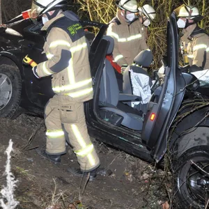 Ein Auto liegt im Seitengraben, darum sind Einsatzkräfte der Feuerwehr