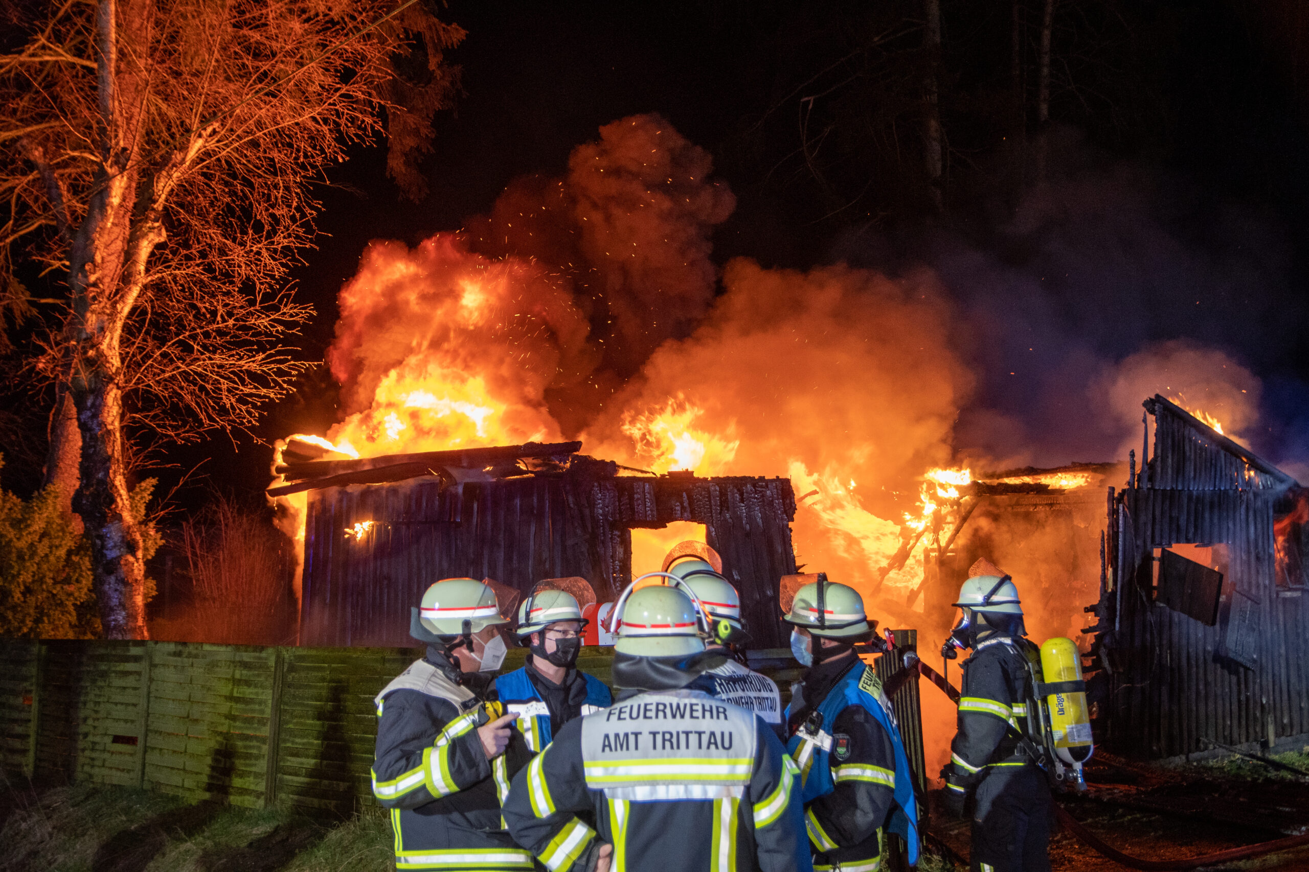 Feuerwehrkräfte vor dem brennenden Ferienhaus in Trittau.